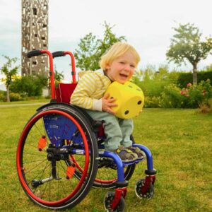 lachender Junge im Kinderrollstuhl Spaß